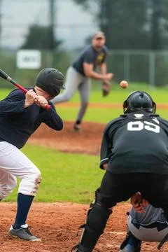 Men playing baseball game. Batter getting ready to hit a pitch during ballg.. Stock Photos