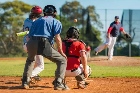 Men playing baseball game. Batter getting ready to hit a pitch during ballg.. Stock Photos