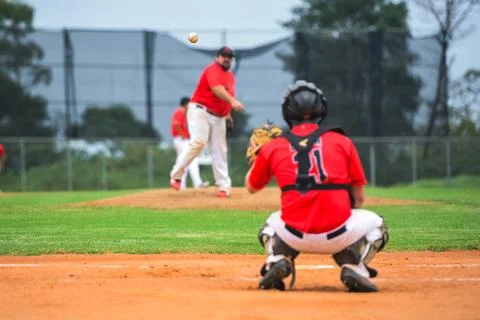 Men playing baseball game. Catcher is getting read to catch baseball during.. Stock Photos