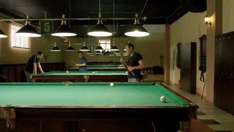 Men playing billiards, hitting balls with cue into pockets on billiard table. 4K Stock Footage 109413746