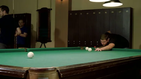 Men playing billiards, hitting balls with cue into pockets on billiard table. 4K 库存影片 109452306