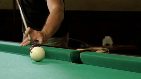Men playing billiards, hitting balls with cue into pockets on billiard table. 4K Stock Footage 109452403