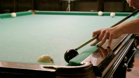 Men playing billiards, hitting balls with cue into pockets on billiard table. 4K Stock Footage 109452481
