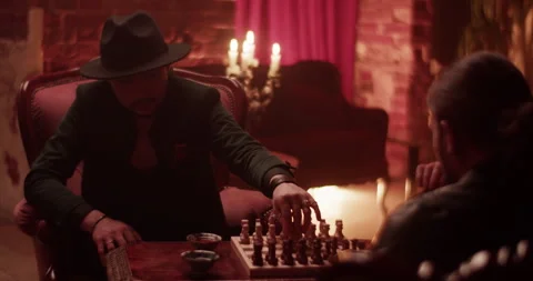 Men playing chess board game in vintage home Video stock 260558273