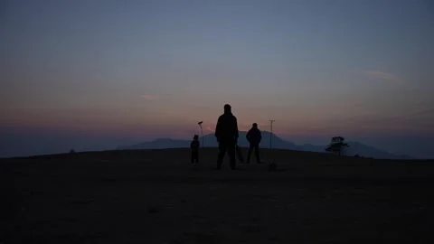 Men playing cricket on rural hilltop at sunset in Nepal Stock Footage 342136106