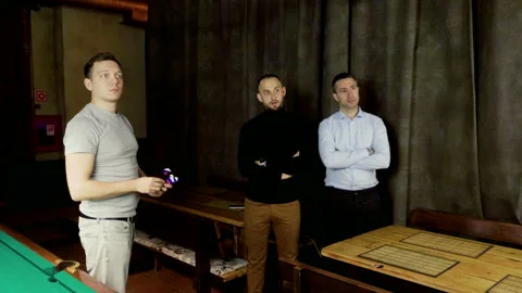 Men playing in game of darts, throwing a dart arrow in center of dartboard. 4K Stock Footage 110794433