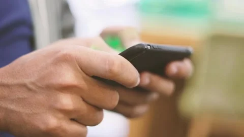 Men playing game user Her Smartphone Outside. Hands Scrolling Screen Closeup Stock Footage 336249157