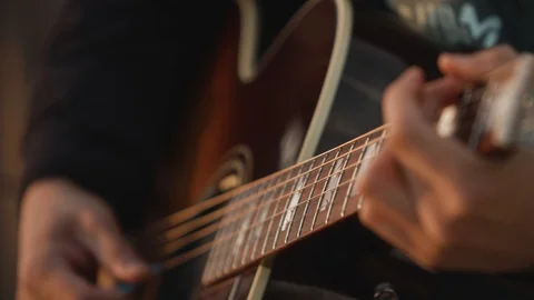 Men playing guitar on the beach at sunset, close up. Slow motion Stock Footage 111430895