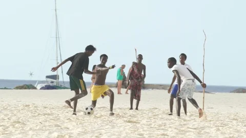 Men playing soccer on sand at beach Stock Footage 85777778
