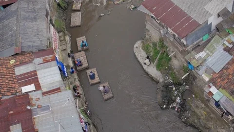 Men by a polluted river in a slum 스톡 동영상 75887193