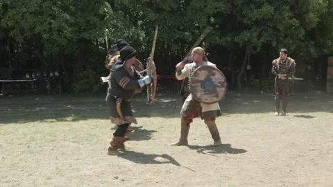 Men practice ancient warrior sword fighting techniques in costume Stock Footage 193367609