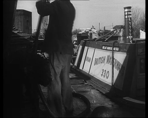 Men prepare and refuel their narrowboats, Bulls Bridge, Southall, UK 1950 Stock Footage 132329783