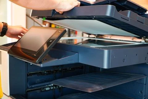 Men press the button of the copier. Man copying paper from Photocopier. Men.. Stock Photos