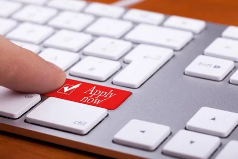Men pressing apply now button on alluminium keyboard Stock Photos