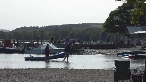 Men pull in boat from Lake Coniston on Sunny summers day Video stock 169700988