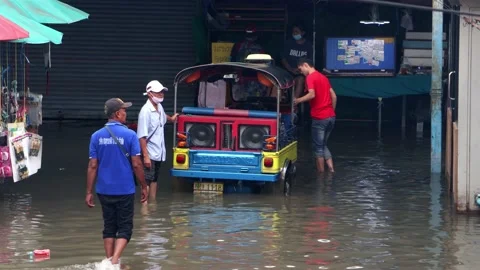 Men pull a Tuk Tuk motor tricycle stuck in a flooded street Stock Footage 233238603