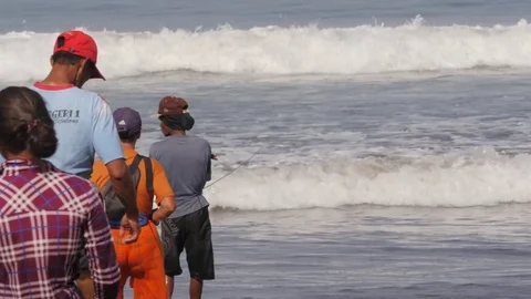 Men pulling fishing net out of sea in Pangandaran Java Indonesia Stock Footage 82079847