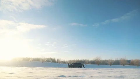 Men push broken van with engine problems in sunny winter day Stock Footage 83268616