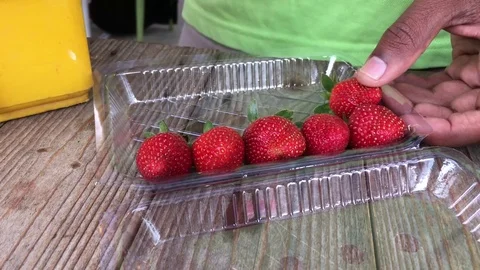 Men put strawberry in plastic packet for sale, h264 codec Stock Footage 81493408
