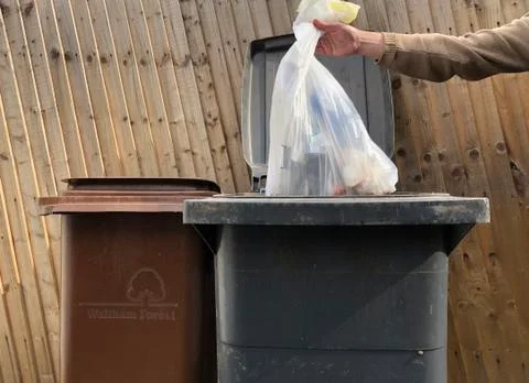 Men putting garbage in bin Foto stock