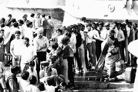 Men in queue looking smiling at women Gateway of India Mumbai India Asia 1... Foto stock