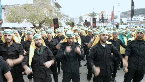 Men raise hands while calling slogans during Hezbollah's Ashoura procession Stock Footage 119945545