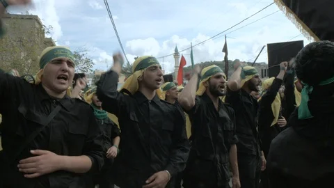 Men raise hands while calling slogans during Hezbollah's Ashoura procession Stock Footage 119945643