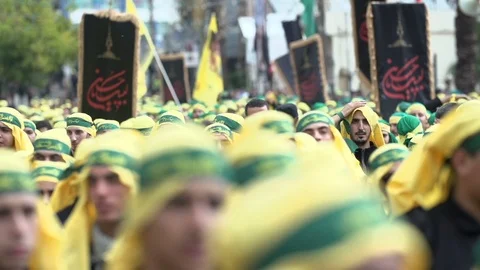 Men raise hands while calling slogans during Hezbollah's Ashoura procession Stock Footage 120589729