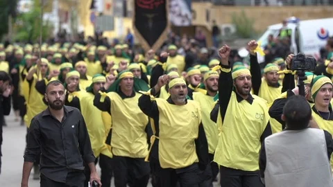 Men raise hands while calling slogans during Hezbollah's Ashoura procession Video stock 120592925
