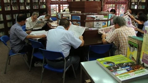 Men read newspapers in a public library in Macau, China. Stock Footage 60988112