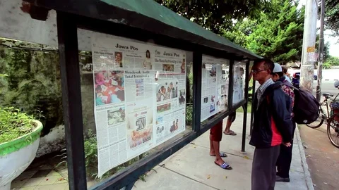Men Read Newspapers On The Public Stand In Indonesia (2 of 4) Stock Footage 86008468