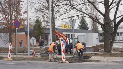 Men in reflective vests working on roadwork construction next to road Stock Footage 122260274