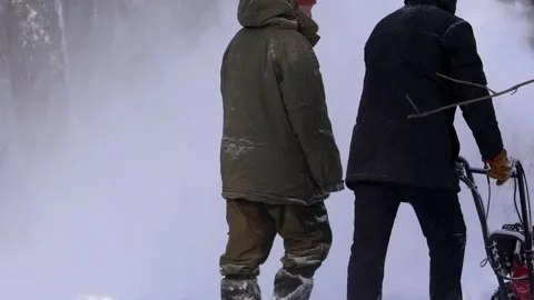 Men remove snow in the park with a snow blower Stock Footage 159439462
