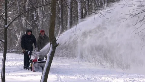 Men remove snow in the park with a snow blower Stock Footage 159443795