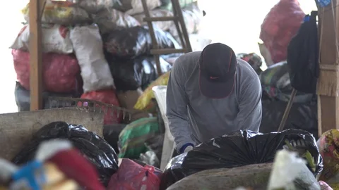 Men in respirators sort garbage. shovels scoop up waste. plastic products, bags. Stock Footage 127369607