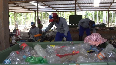 Men in respirators sort garbage. used plastic bottles in the foreground Stock Footage 127369096