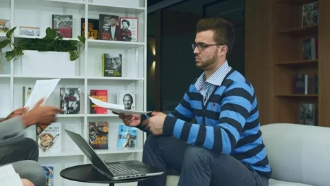 Men Reviewing Documents and Laptop in Modern Office Meeting Room Warsaw Video stock 340265692