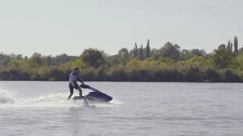 Men ride a jetski on a river Vídeos de archivo 96219666