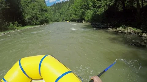 Men rob with a paddle on rafting boat. Rafting boat on the fast mountain river 库存影片 77314655