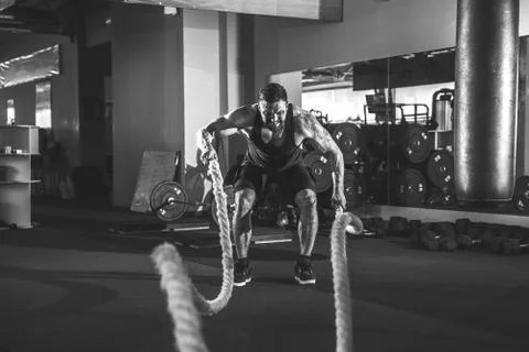 Men with rope in functional training gym 库存照片