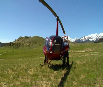 Men rummage in red helicopter after landing Stock Footage 21602494