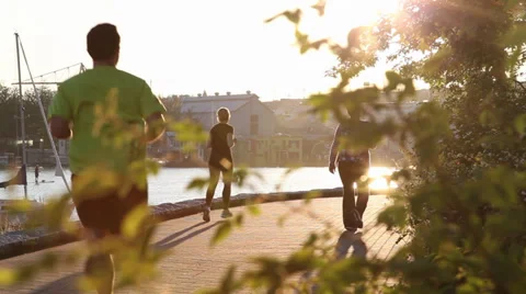 Men running at the seawall Stock Footage 30684276
