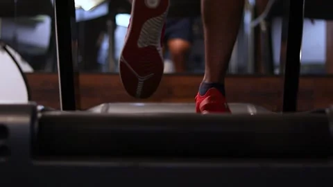 Men running on Treadmill  foot only shot with gimbal in low light Video stock 132667685