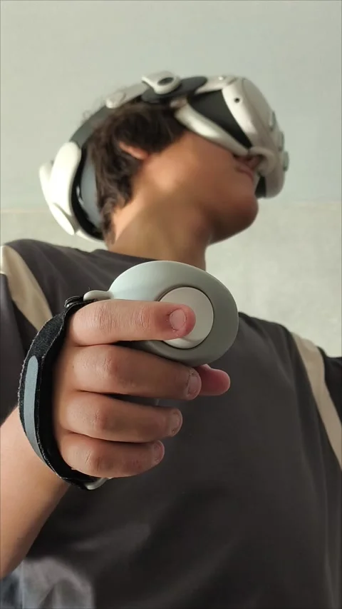 Men s gloved hands for playing VR glasses .Teen malchik is playing video games 動画素材 313268411