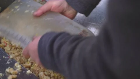 Men 's hands are raking out crushed apple paste for cider production mushed by Stock Footage 167701741