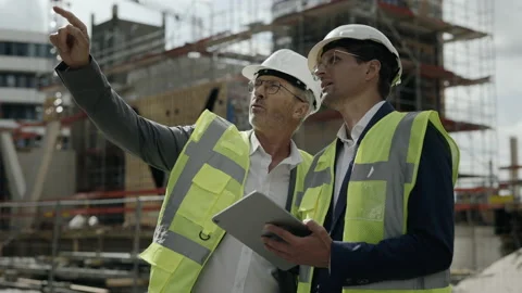 Men in safety helmets using tablet on construction site Video stock 167225859