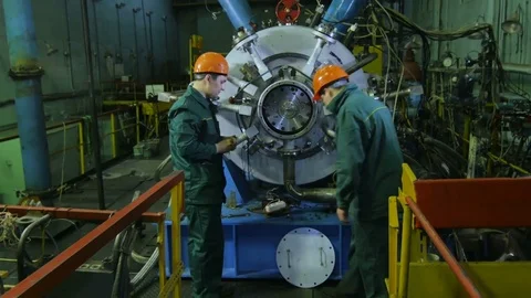 Men Screw Compressor Cover against Equipment in Plant Stock Footage 78873616