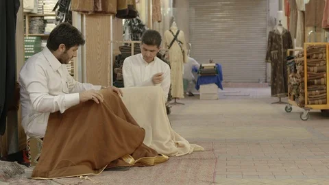 Men sewing to Saudi outfit﻿ In front of the store. Saudi Arabia Stock Footage 113665576