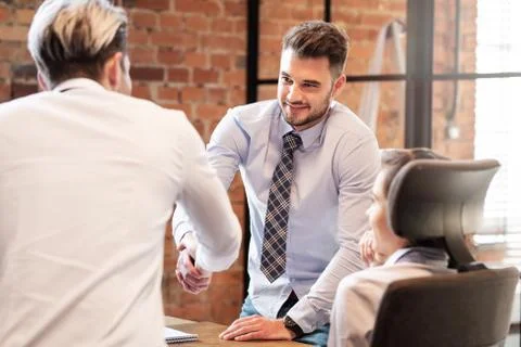 Men shaking hands while working in team 스톡 사진