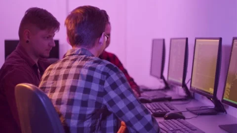 Men in shirts programmers discuss work sitting in the office at computers. Stock Footage 147224701